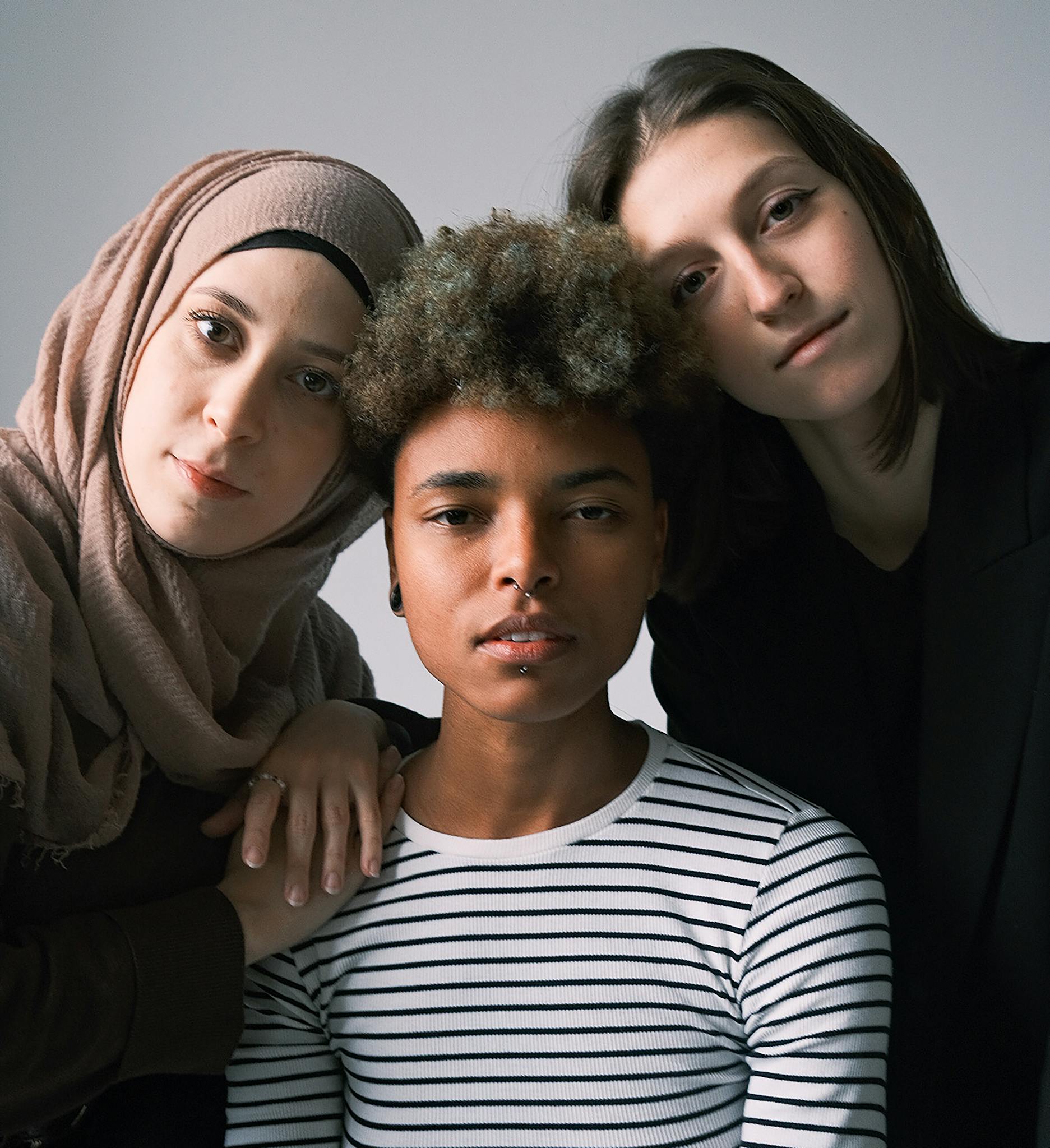 Portrait of three diverse adults showcasing cultural and ethnic harmony.
